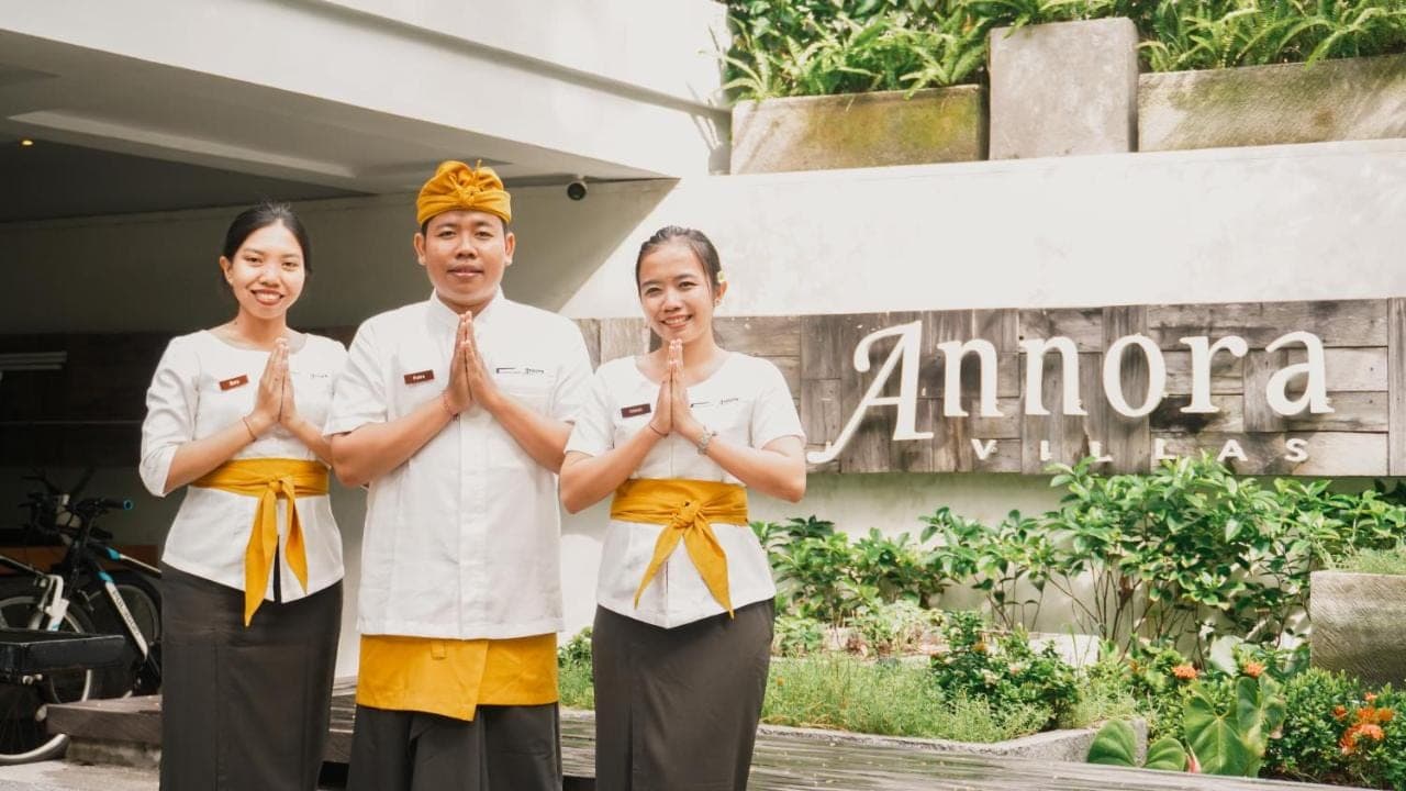 a group of three people praying in front of a building at Annora Villas Seminyak in Seminyak