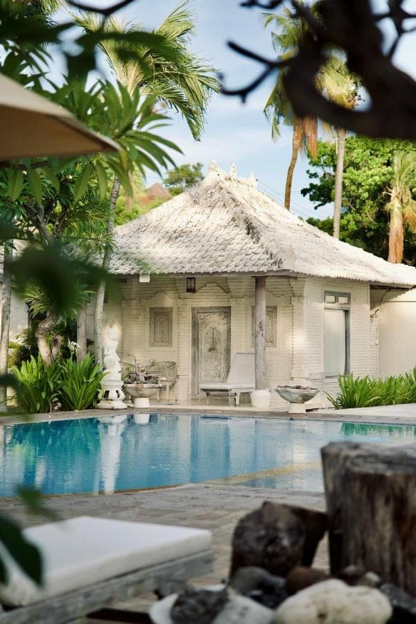 a resort with a swimming pool in front of a building at Dhauteya Villa in Amed