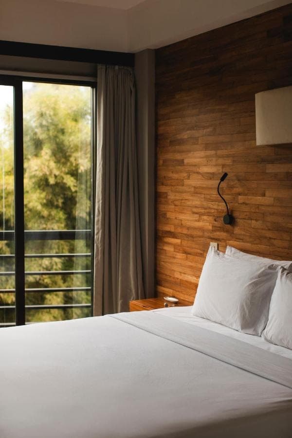 a bedroom with a bed and a large window at Surf Motel Bali in Canggu