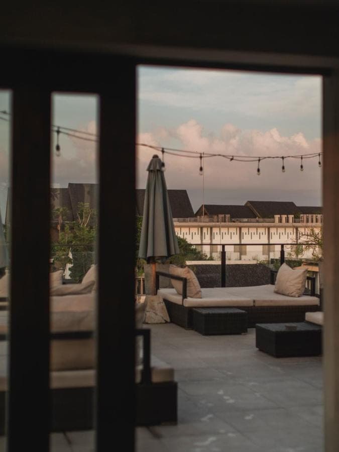 a view of a patio with couches and an umbrella at Surf Motel Bali in Canggu