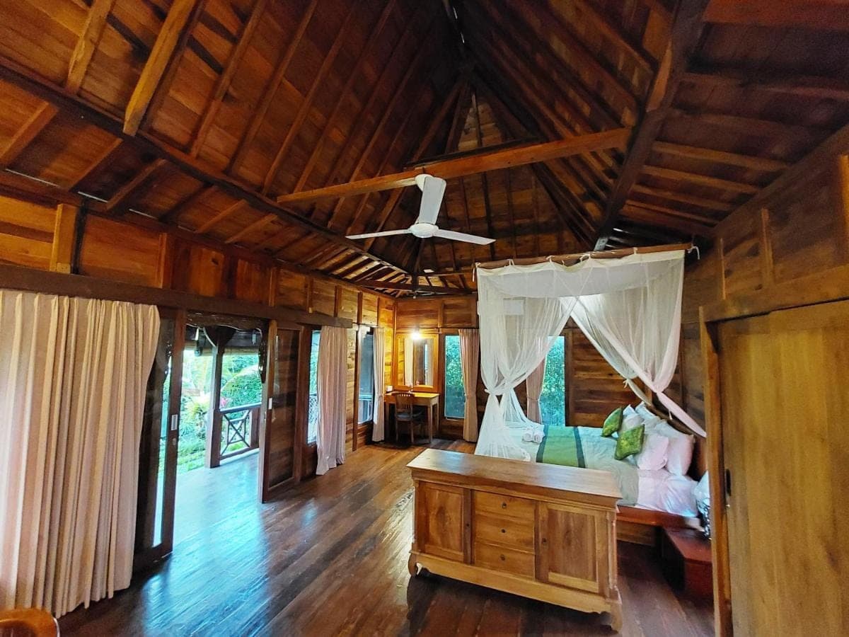 a bedroom with a bed and a ceiling at Shivananda Antique Villas by EPS in Ubud