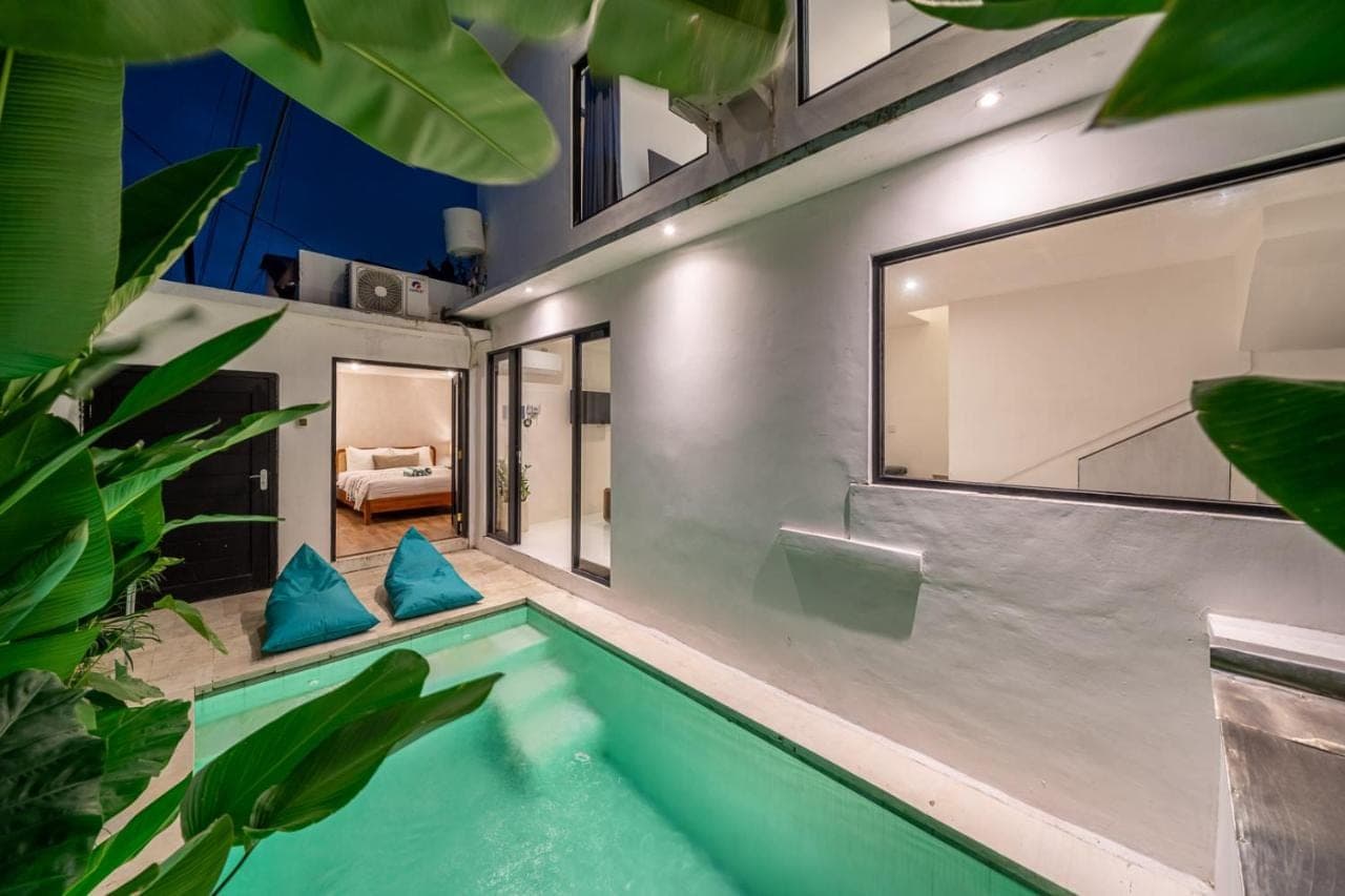 an indoor pool in a house with blue pillows at Nyma 2BR Villa Seminyak in Seminyak