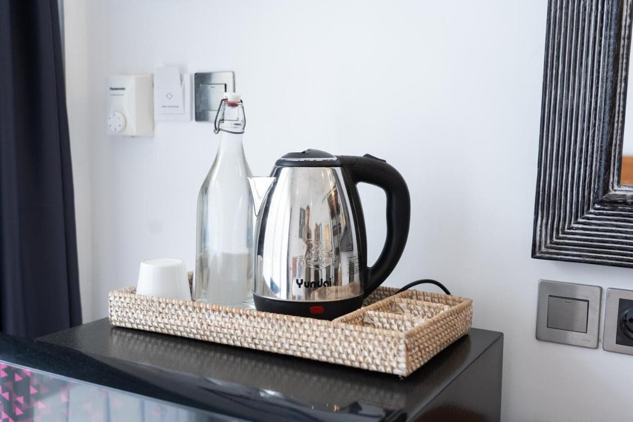 a tea kettle and a bottle on a table at Easy Surf Camp in Kuta