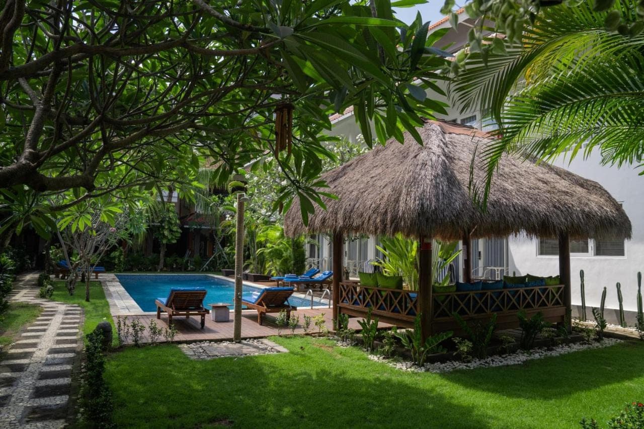 a villa with a swimming pool and a resort at Easy Surf Camp in Kuta