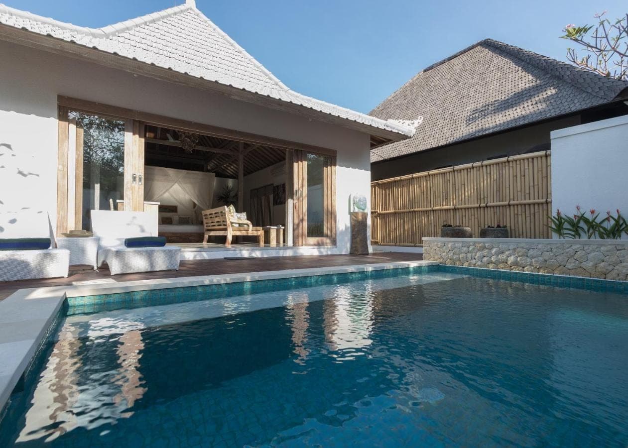 a swimming pool in front of a house at Aloha Beach House Bingin Villas in Uluwatu