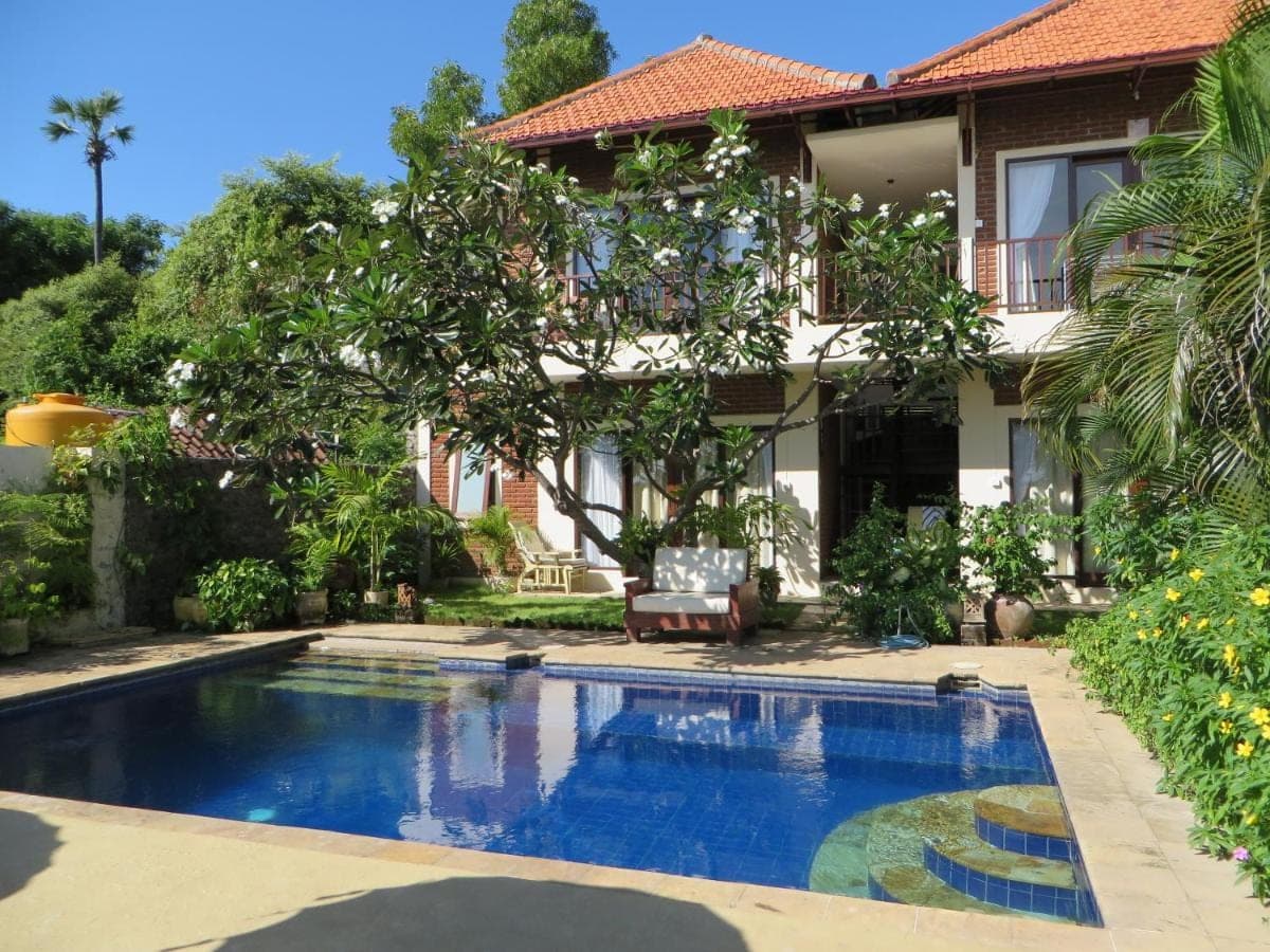 a swimming pool in front of a house at Jukung Dive Resort Bali AMED in Amed