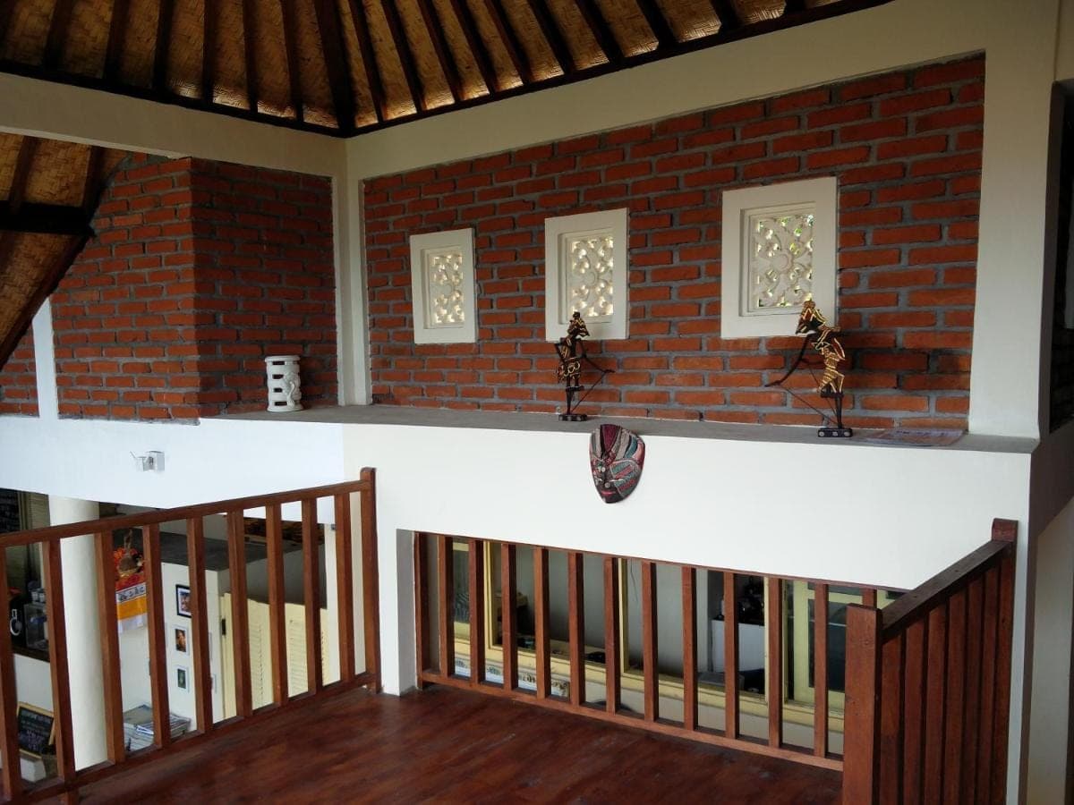 a staircase in a room with a brick wall at Jukung Dive Resort Bali AMED in Amed