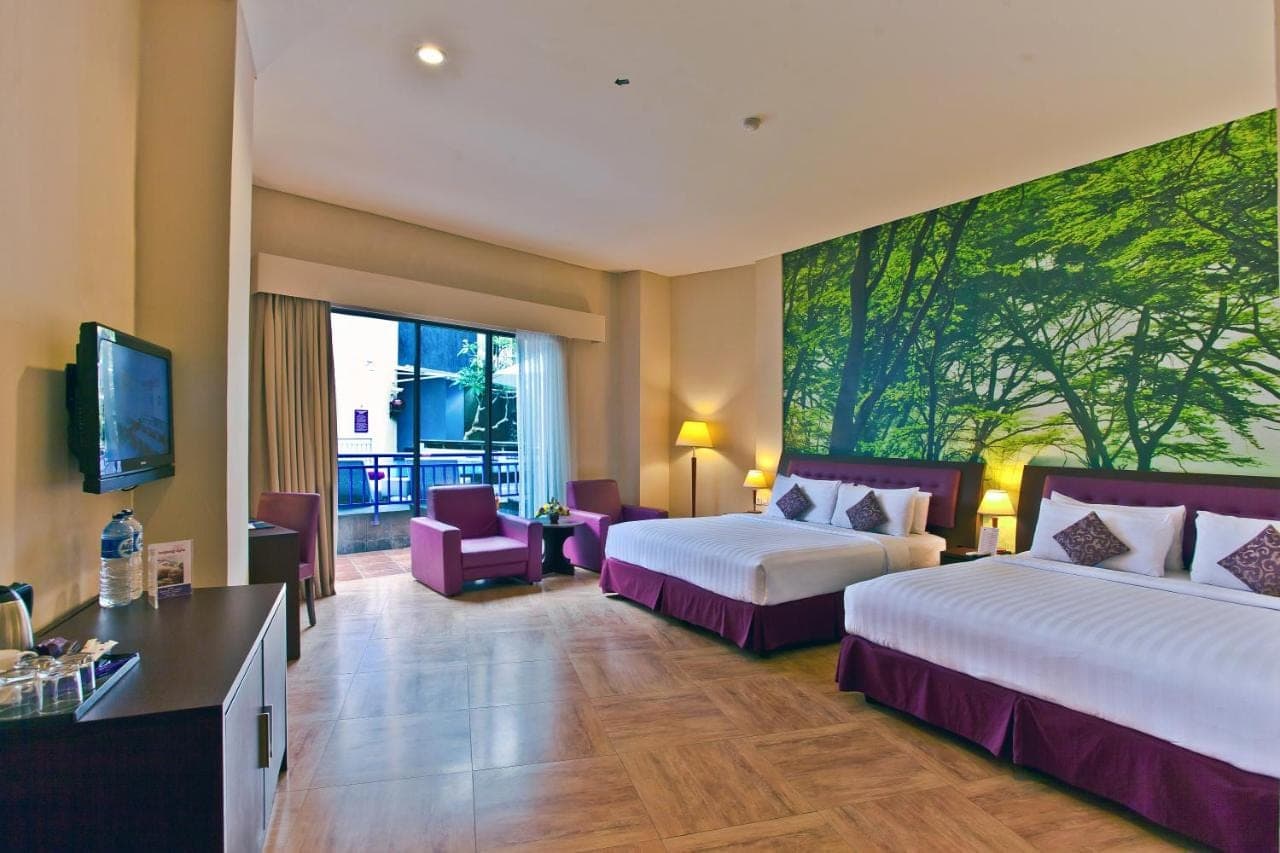 a hotel room with two beds and a large painting on the wall at Kuta Central Park Hotel in Kuta