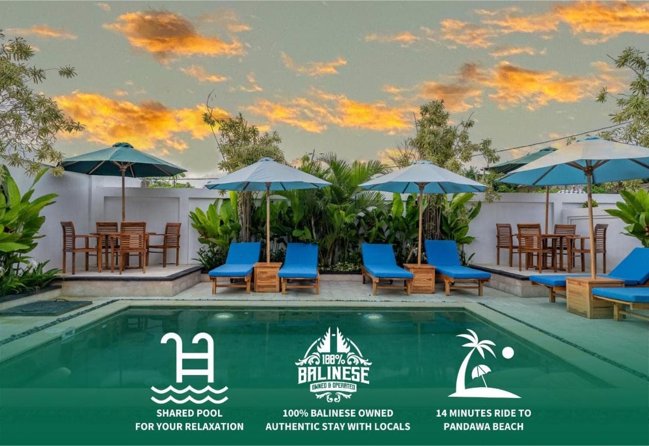 a swimming pool with blue chairs and umbrellas at The Pandawa Bali by Bukit Vista in Nusa Dua