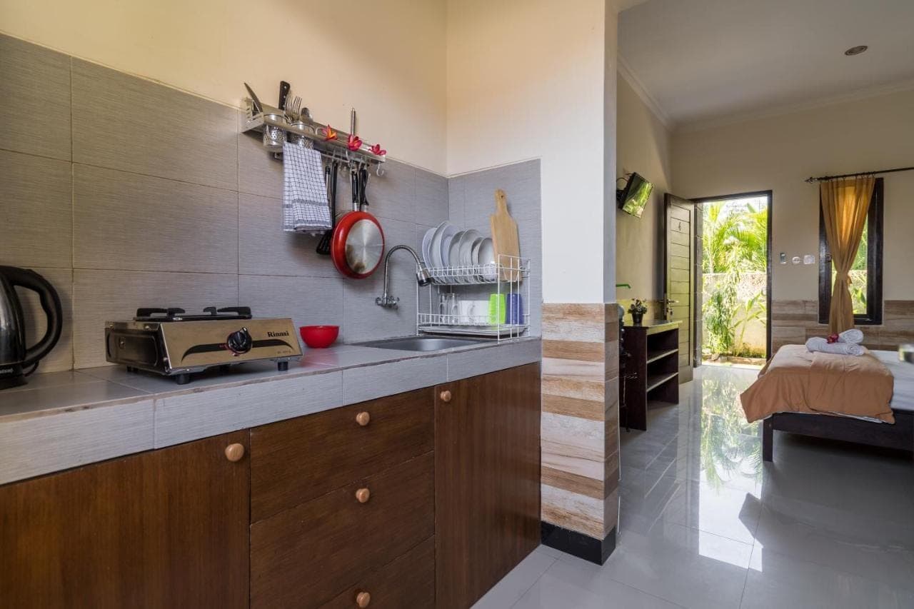 a kitchen with a sink and a counter with a microwave at Kubu Lestari Homestay in Sanur