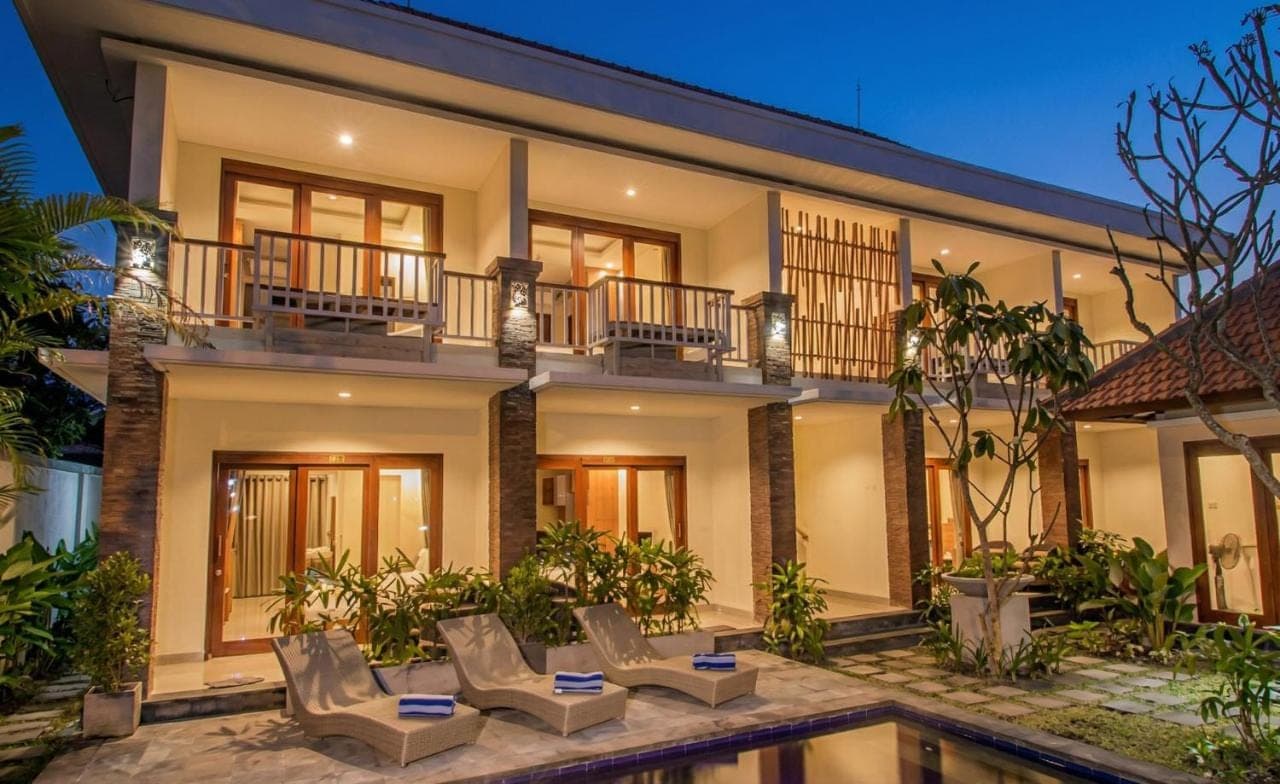 an exterior view of a house with chairs and a swimming pool at Anindya Sanur in Sanur