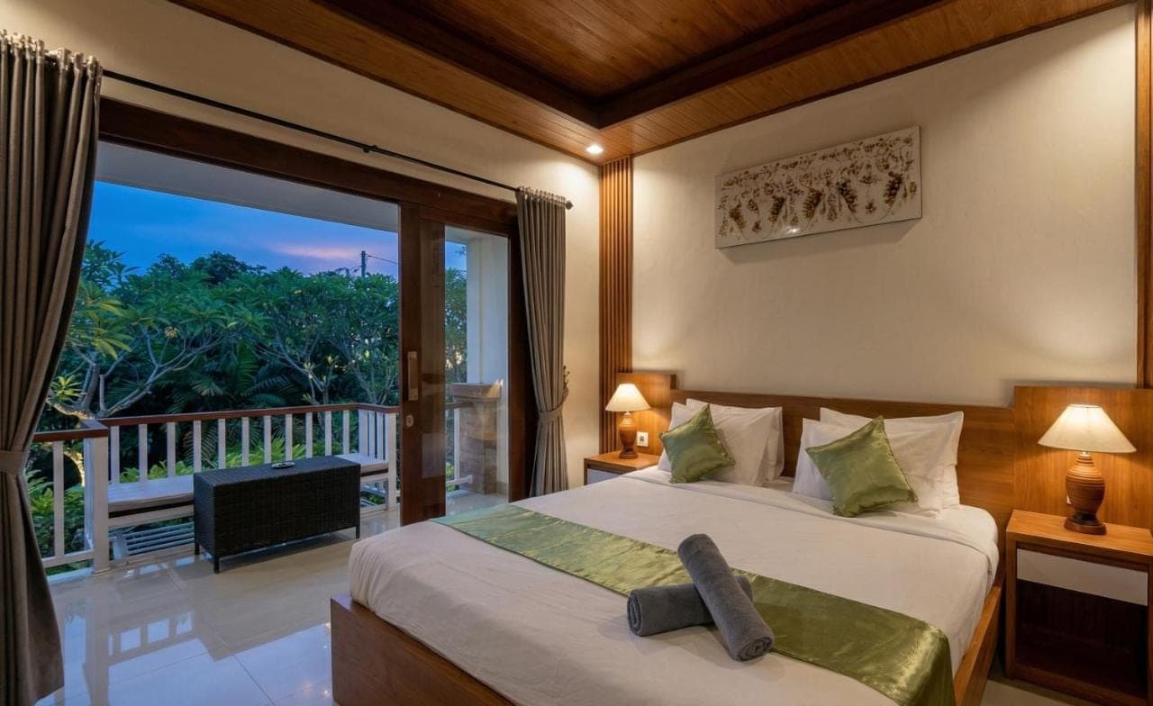 a bedroom with a bed and a large window at Anindya Sanur in Sanur