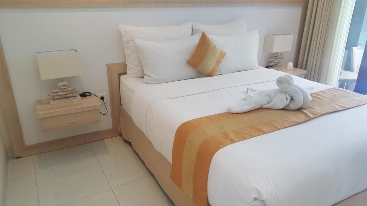 a hotel room with two beds with a stuffed animal on the bed at Nyaman Guest House in Sanur