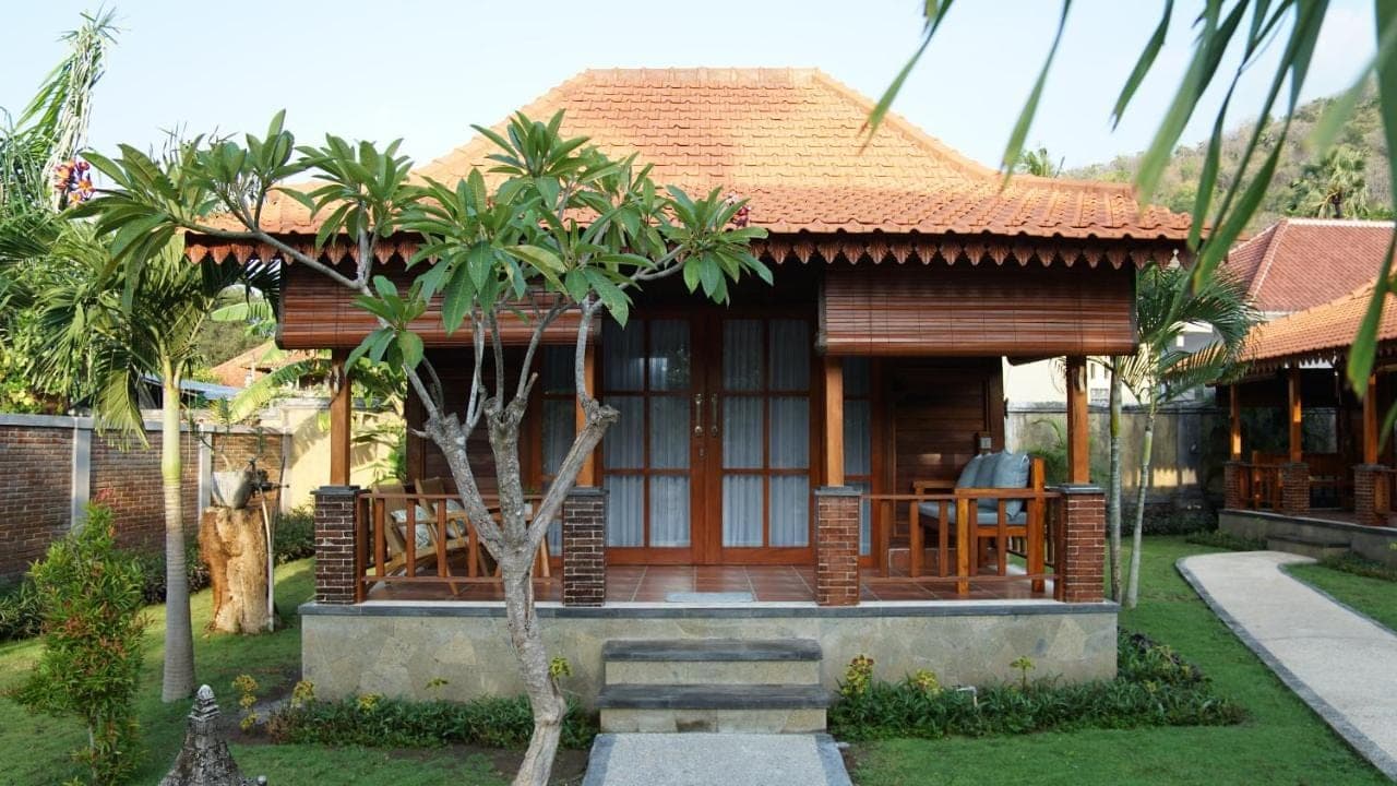 a small house with a porch and a house at Kubu Kangin Resort in Amed