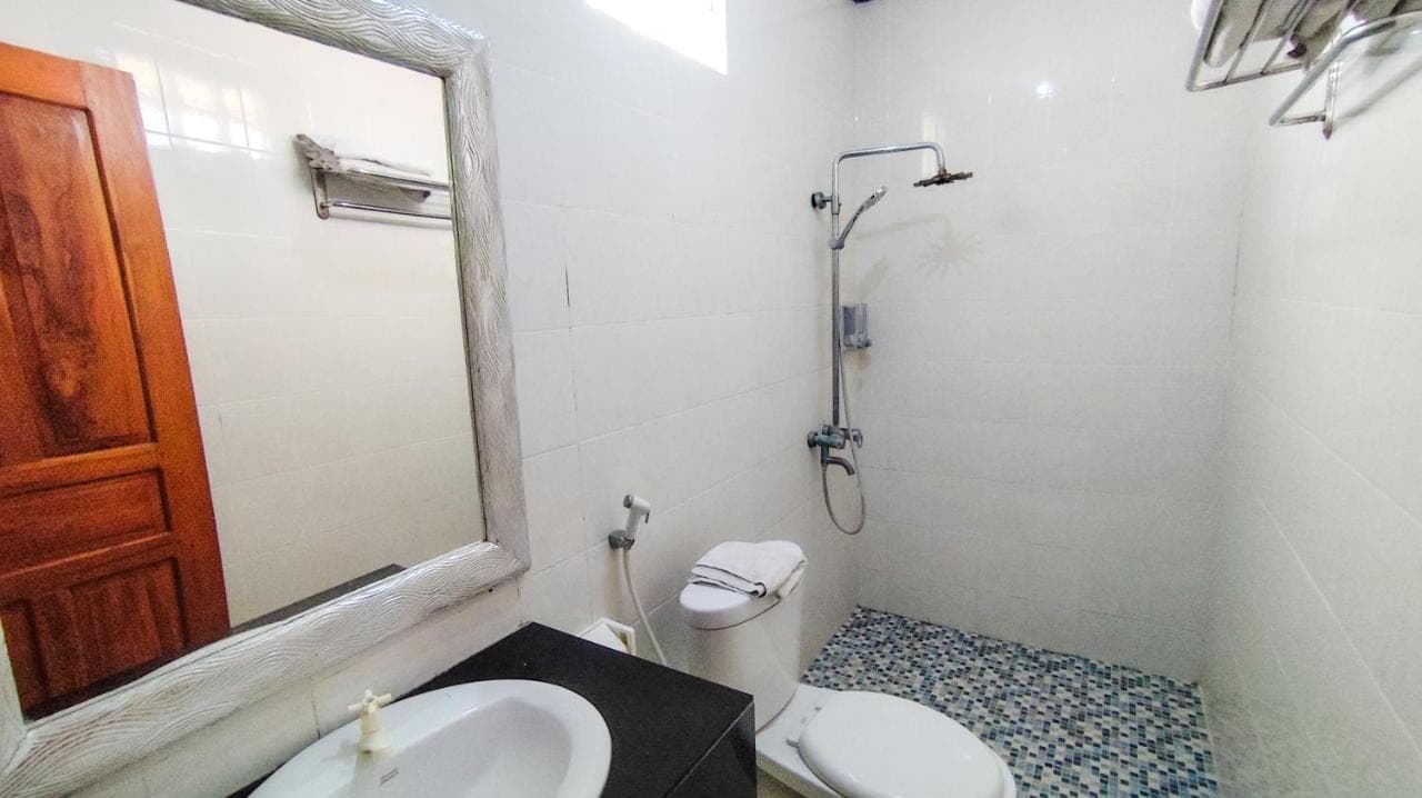 a bathroom with a toilet and a sink and a mirror at Oemah Bali in Nusa Dua