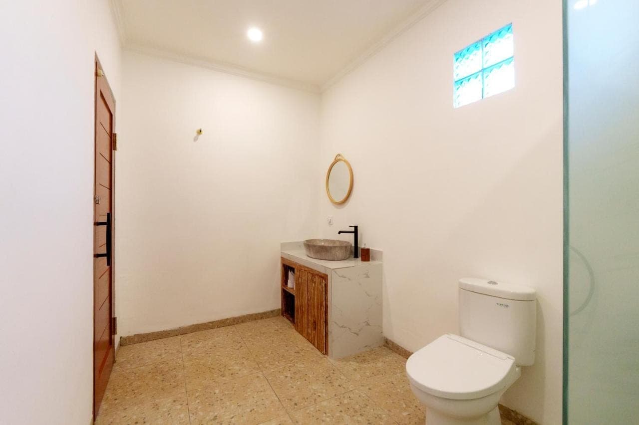 a bathroom with a toilet and a sink at The Sanja Uluwatu in Uluwatu