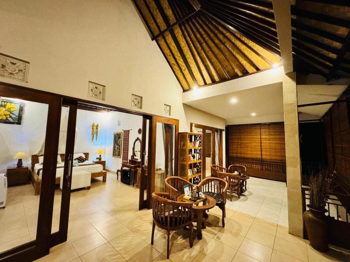a living room with a table and chairs and a couch at Uma Agung Villa in Sidemen