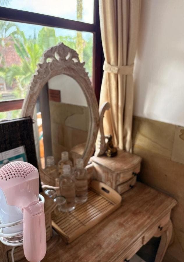 a dressing table with a mirror and a hair dryer at Uma Agung Villa in Sidemen