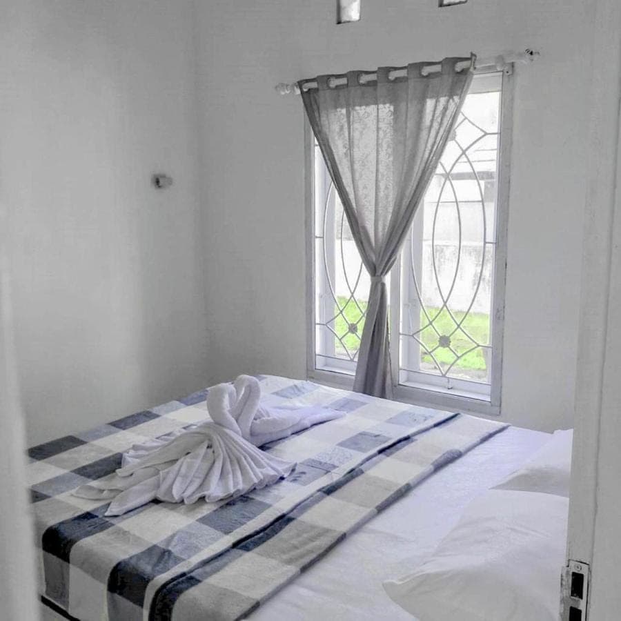 a bed in a room with a window at Pigeon House Nusa Dua in Nusa Dua