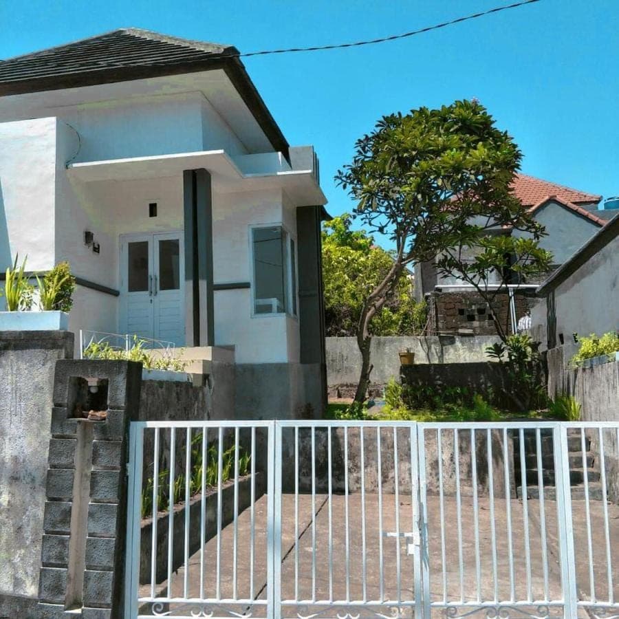 a white fence in front of a white house at Pigeon House Nusa Dua in Nusa Dua