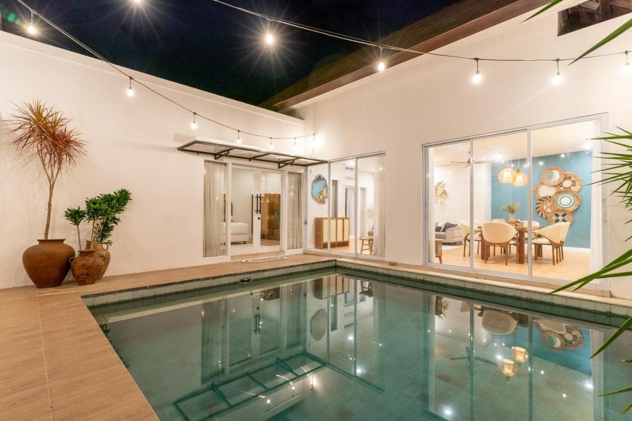 an indoor swimming pool in a house at Villa Palma Blanca Canggu by Nagisa Bali in Canggu