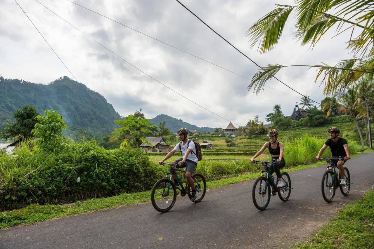 a group of people riding bikes down a road at Wapa di Ume Sidemen in Sidemen