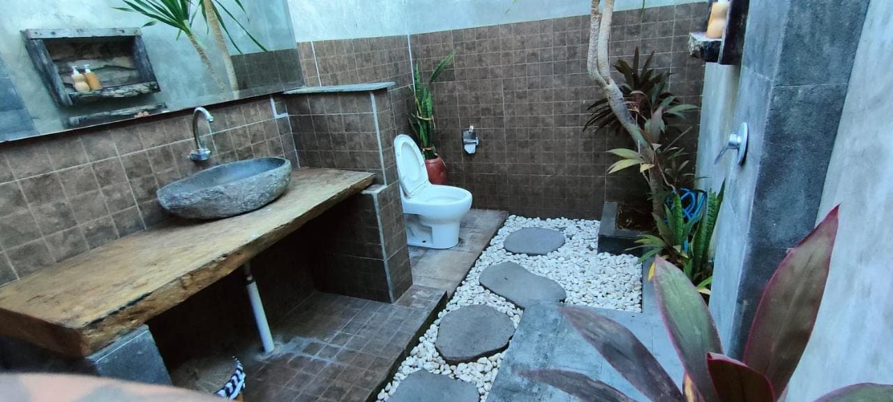 a bathroom with a sink and a toilet at Yogi Beach Cabin in Amed
