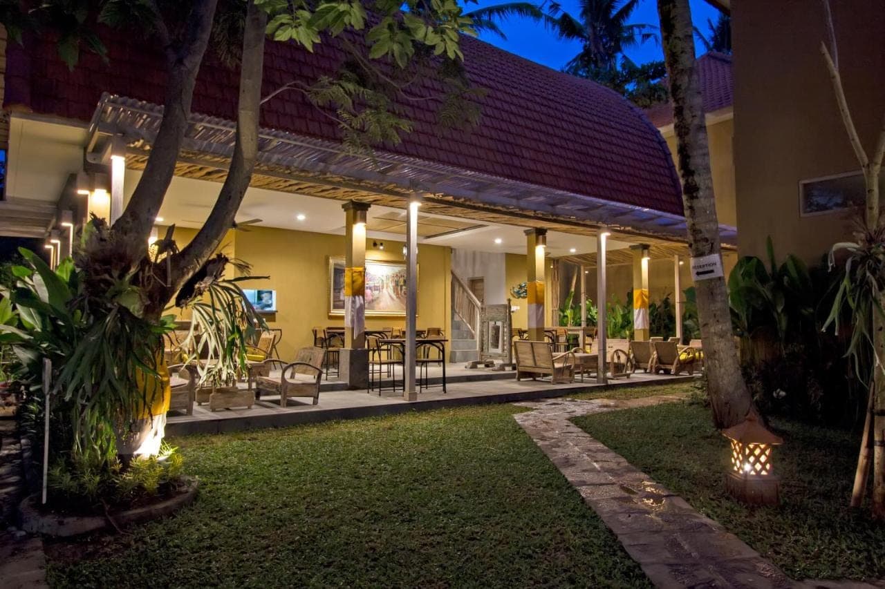 a resort patio with tables and chairs at night at Ubad Retreat, Ubud in Ubud