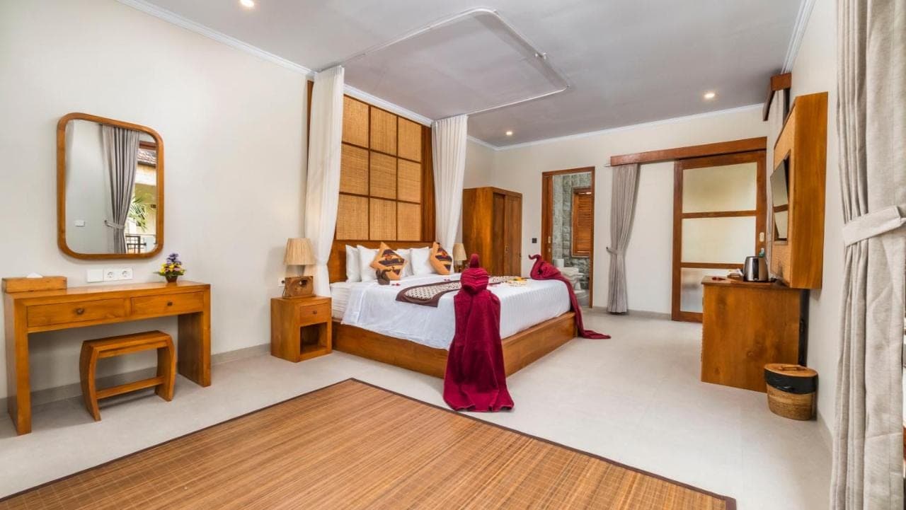 a bedroom with a large bed and a mirror at Arimba at Bisma in Ubud