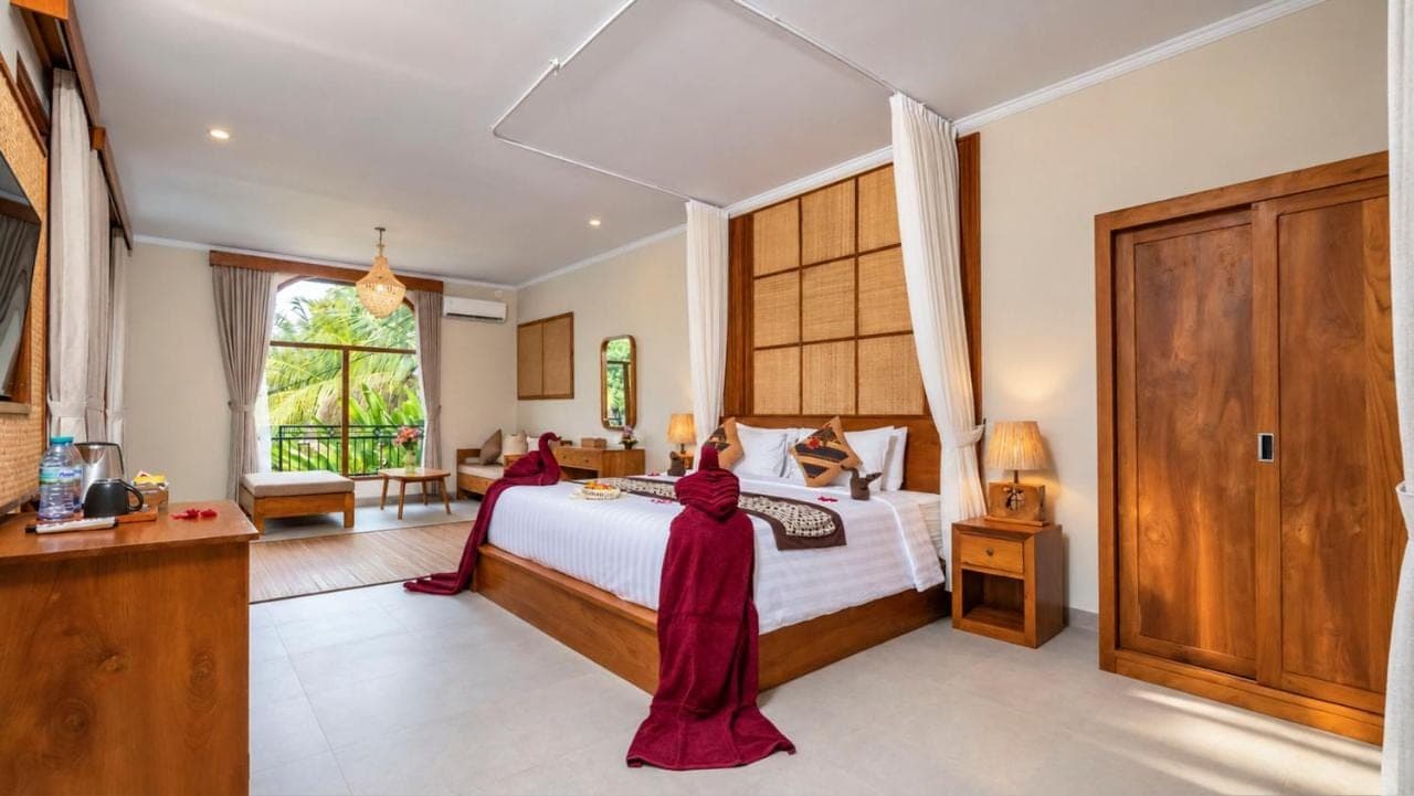 a bedroom with a large bed and a large window at Arimba at Bisma in Ubud