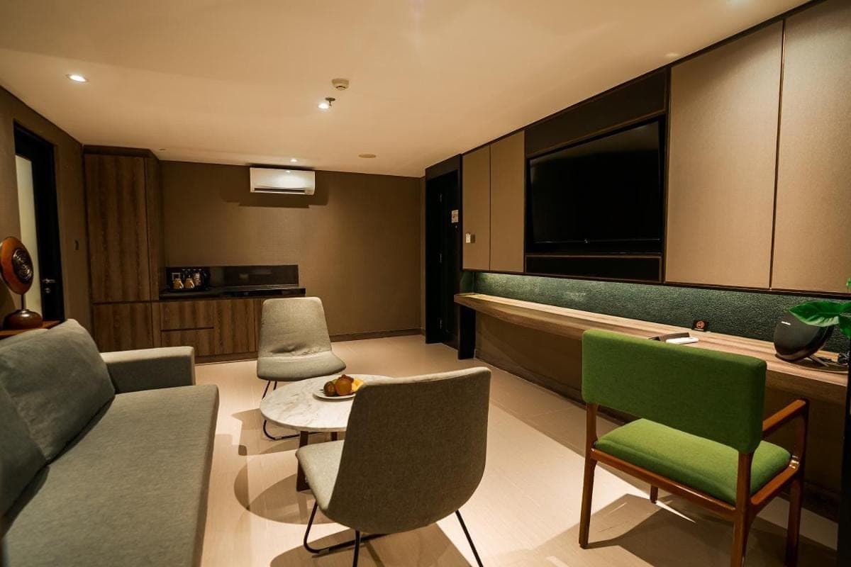 a living room with a couch and chairs and a tub at The Nest Hotel Nusa Dua in Nusa Dua
