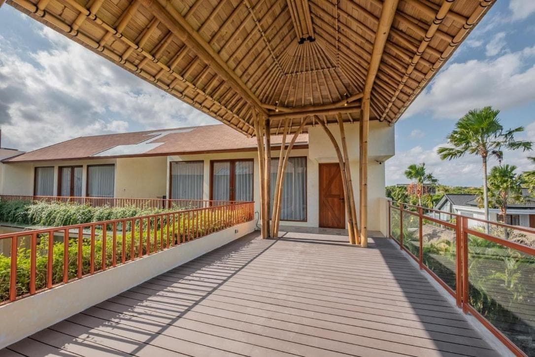 a balcony of a house with a wooden walkway at Ellisani Bali in Canggu