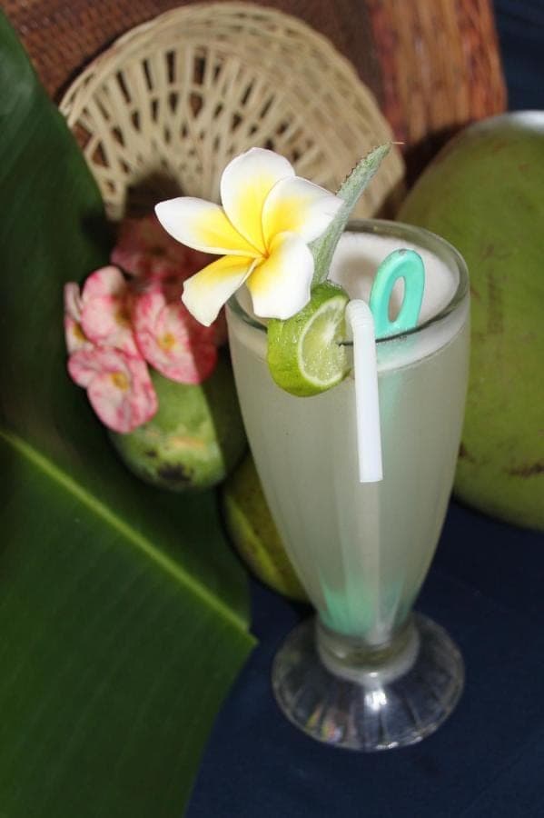 a drink with a flower on top of a table at Blue Star Bungalows &amp; Cafe in Amed
