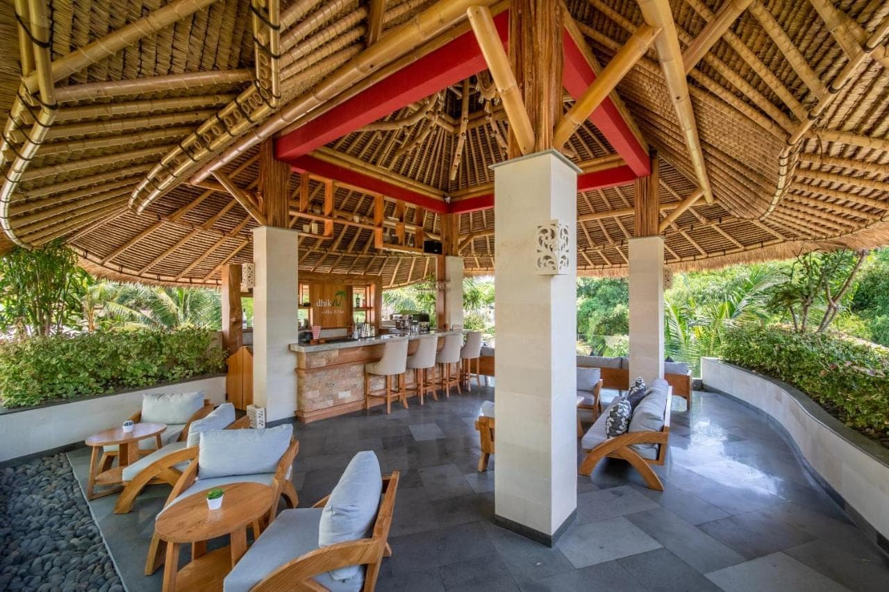 an outdoor restaurant with chairs and a bar at Harsono Boutique Resort Bali in Sanur