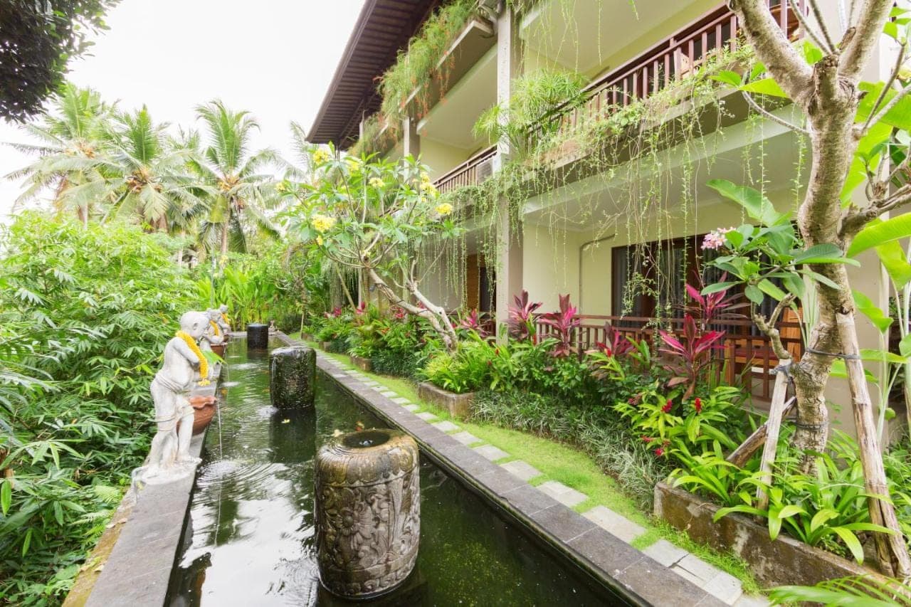 a garden in front of a building at Alamdini Resort Ubud in Ubud