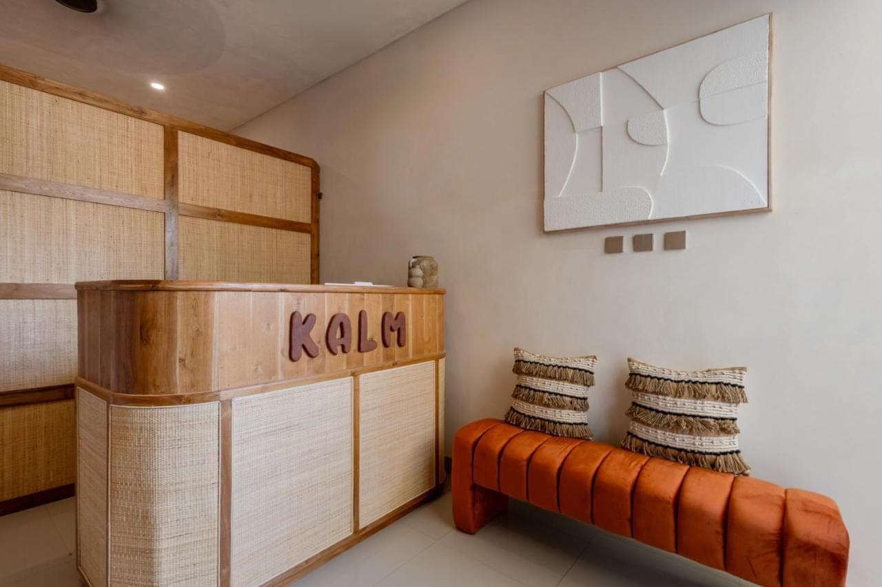 a room with a wooden bench in a room at KALM Bali in Canggu