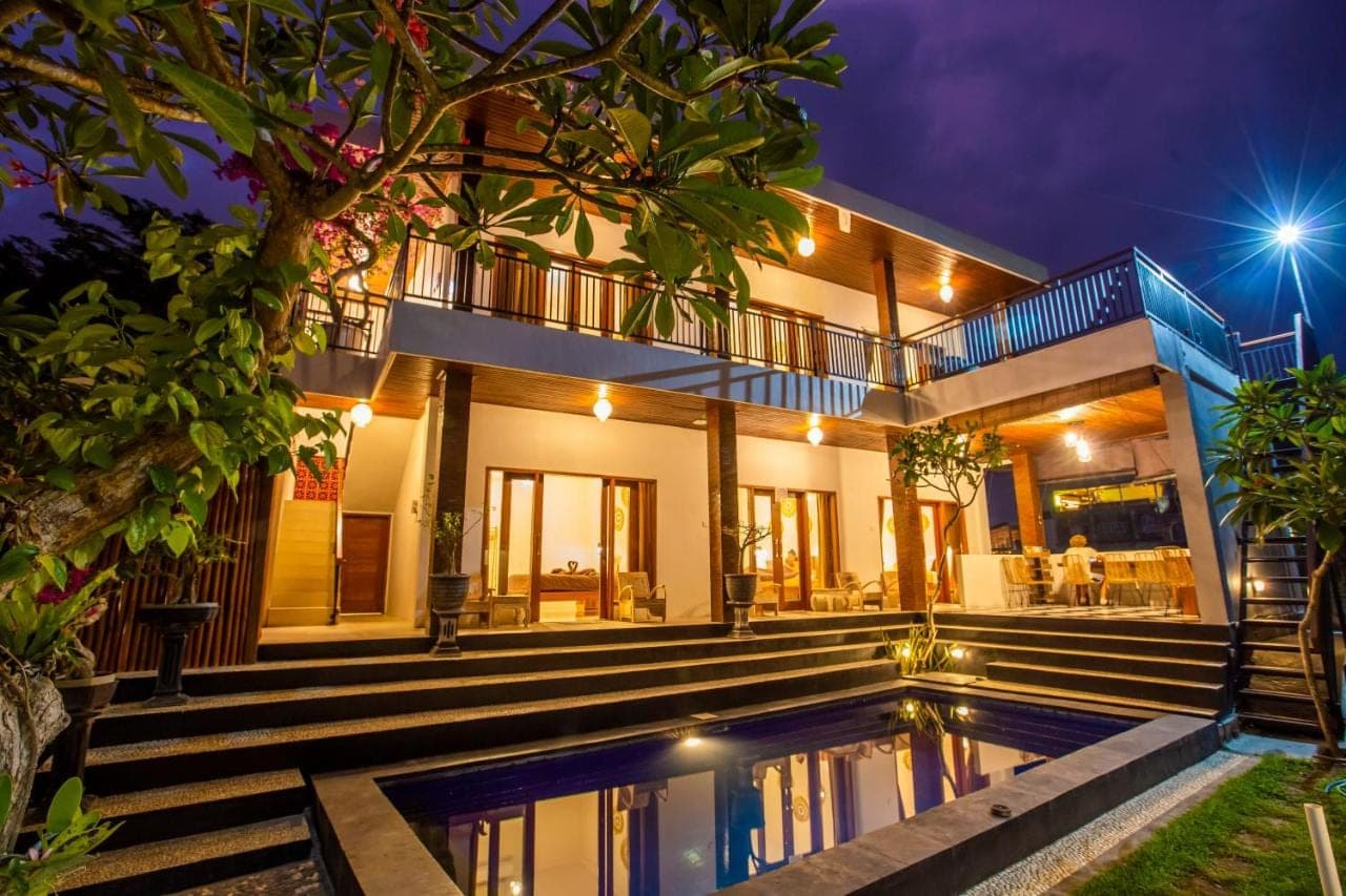 a villa with a swimming pool at night at The Nest Canggu in Canggu