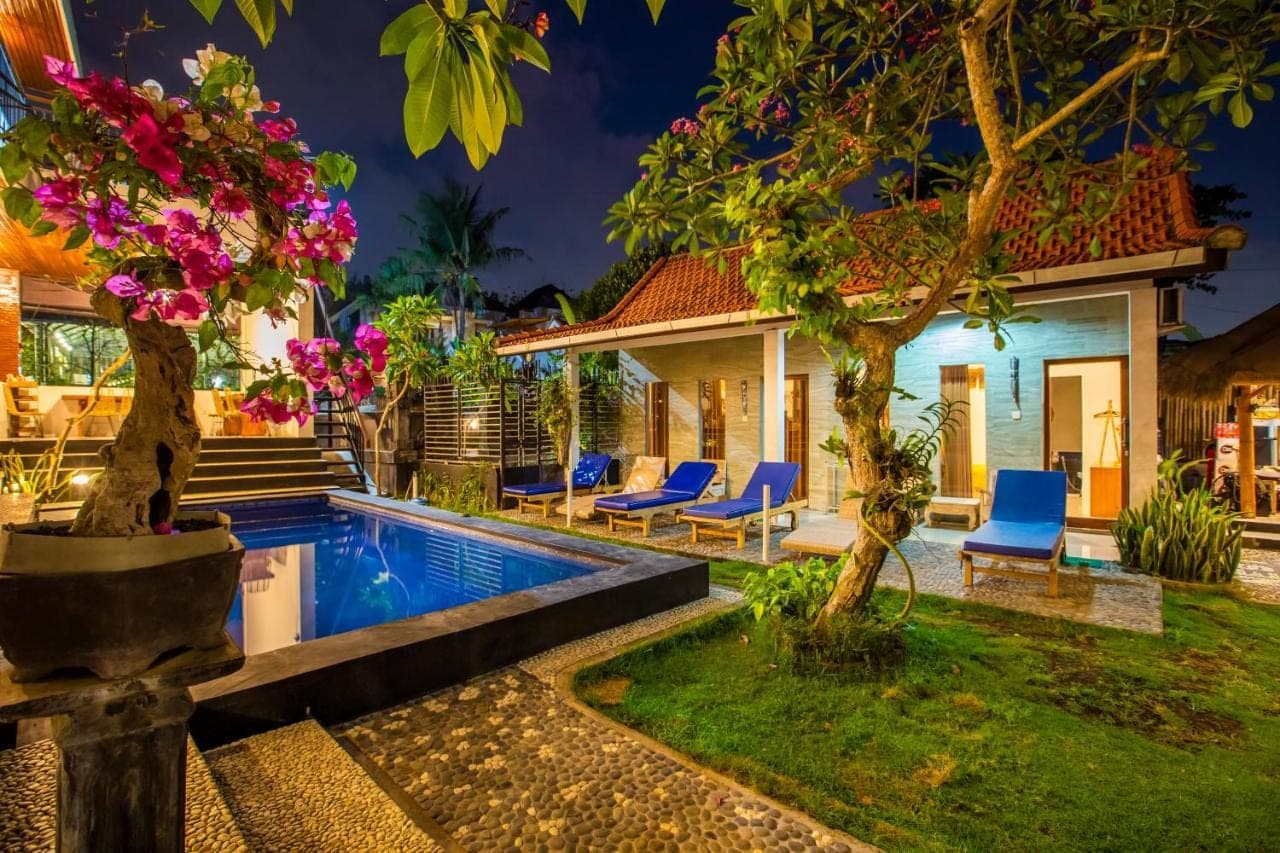 a villa with a swimming pool at night at The Nest Canggu in Canggu