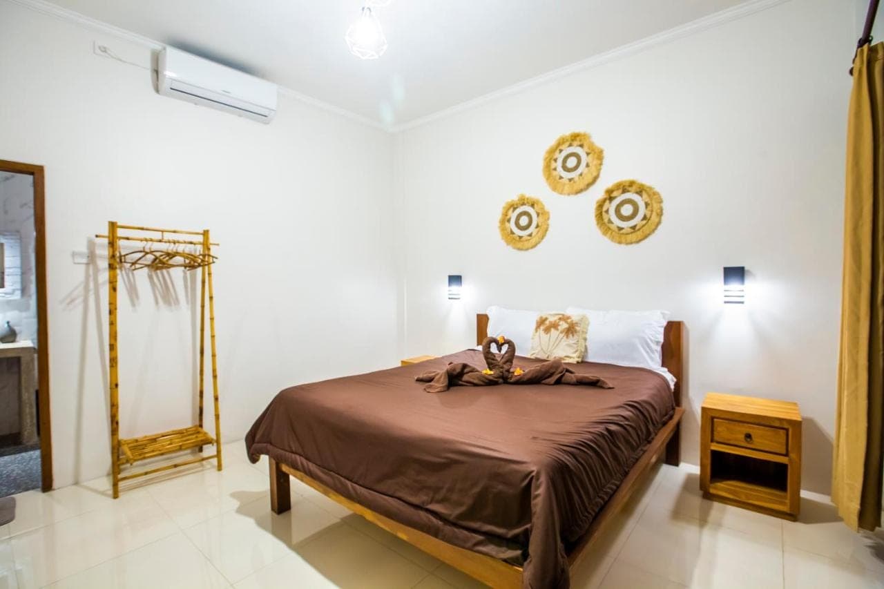 a bedroom with a bed with two stuffed animals on it at The Nest Canggu in Canggu
