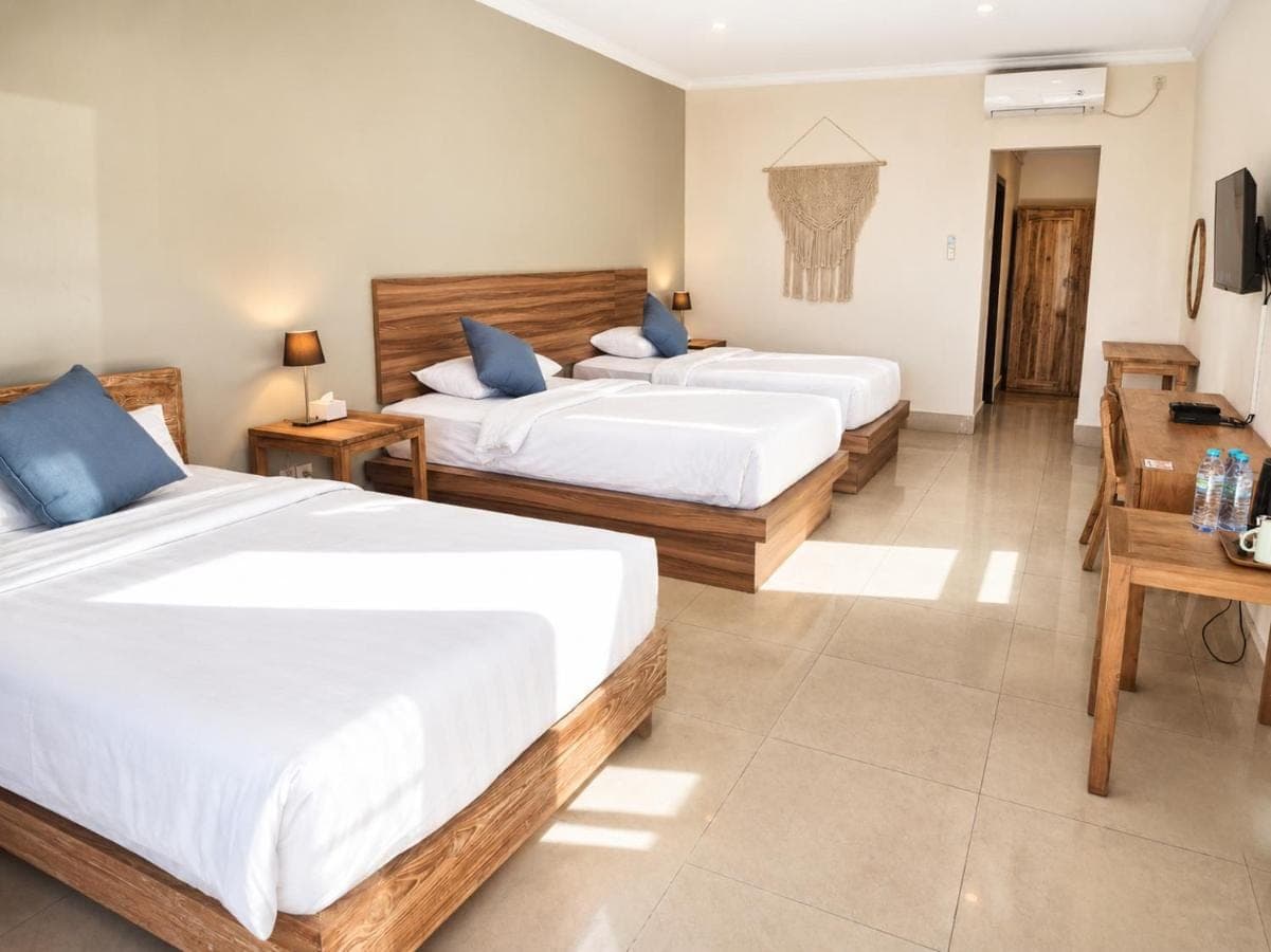 a hotel room with two beds and a desk at Radha Bali Hotel in Kuta