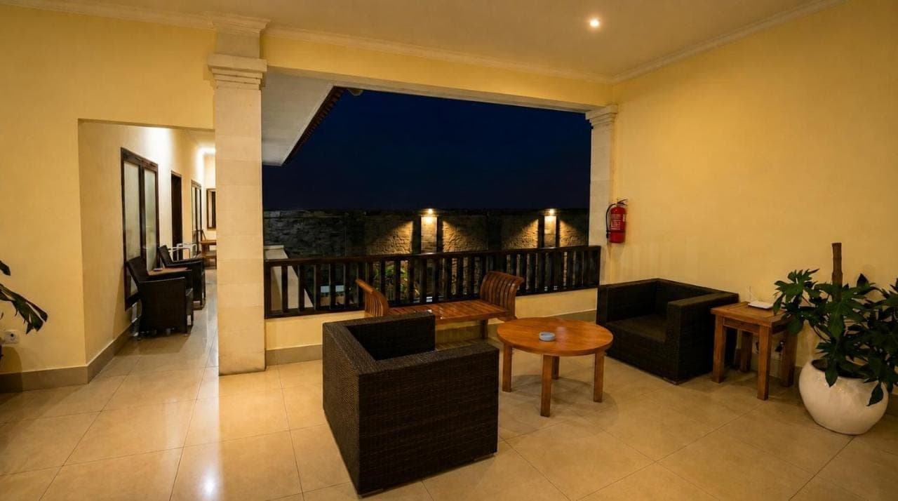 a room with a balcony with a table and chairs at Radha Bali Hotel in Kuta