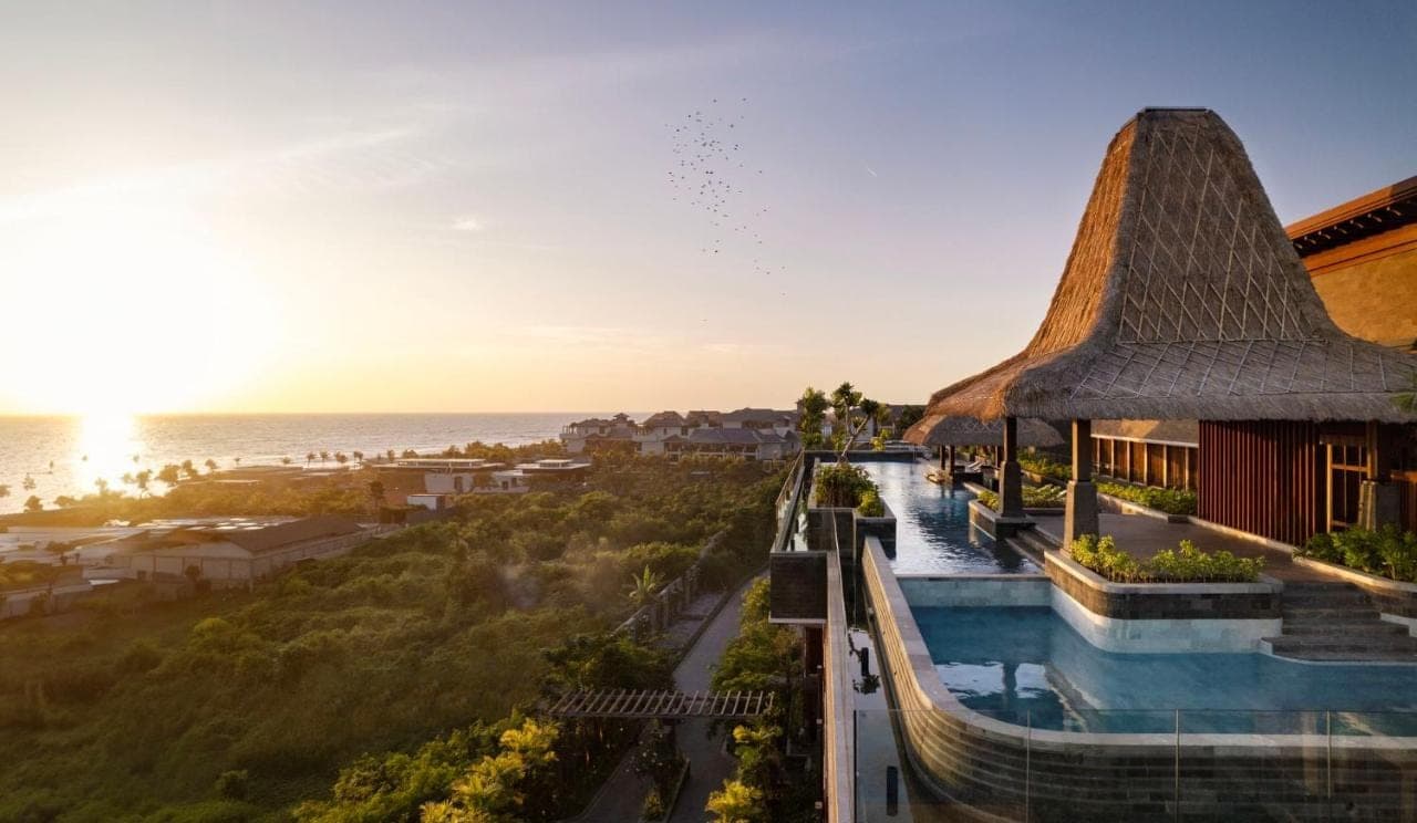 a view of a resort with a pool and the ocean at Holiday Inn Resort Bali Canggu by IHG in Canggu