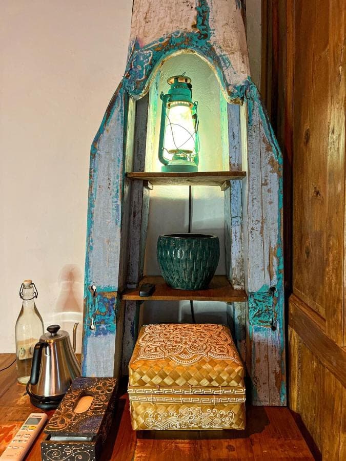 a shelf with a clock and a bowl on a table at Blue Earth Village in Amed