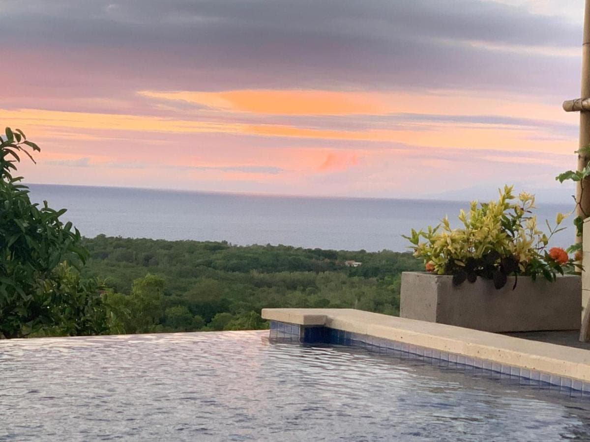 a swimming pool with a view of the ocean at Padawatu Villas in Uluwatu