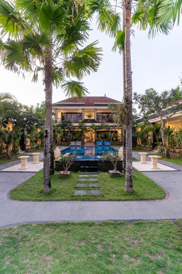 a house with palm trees in front of it at Benian Villas in Nusa Dua