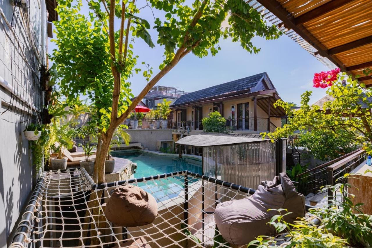 a view of a pool from the balcony of a house at Home-Bience Hostel in Uluwatu