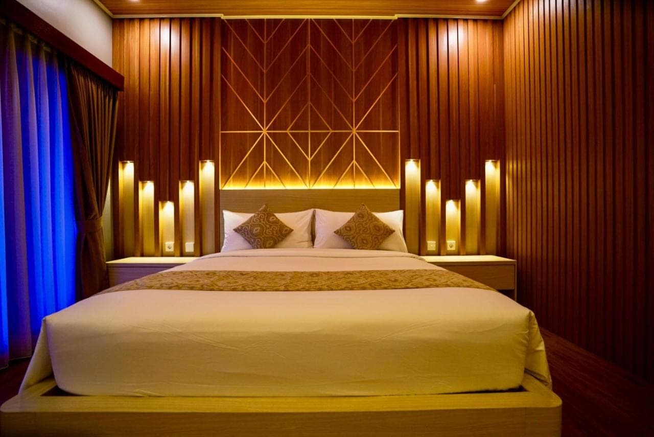 a bedroom with a large bed with lights on it at Bali Banana Guest House in Canggu