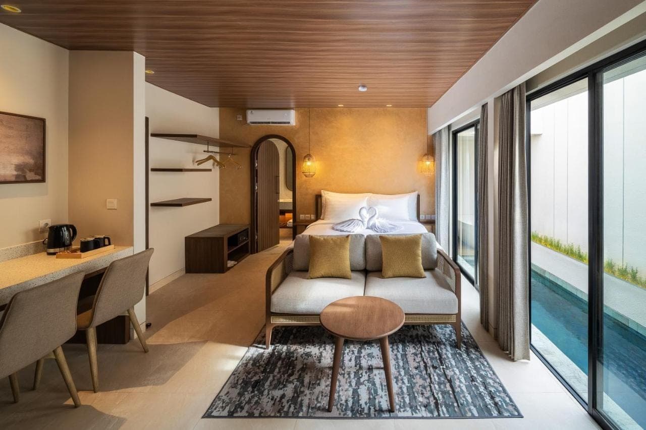 a bedroom with a bed and a desk and a table at Solaris Villa Bali in Kuta