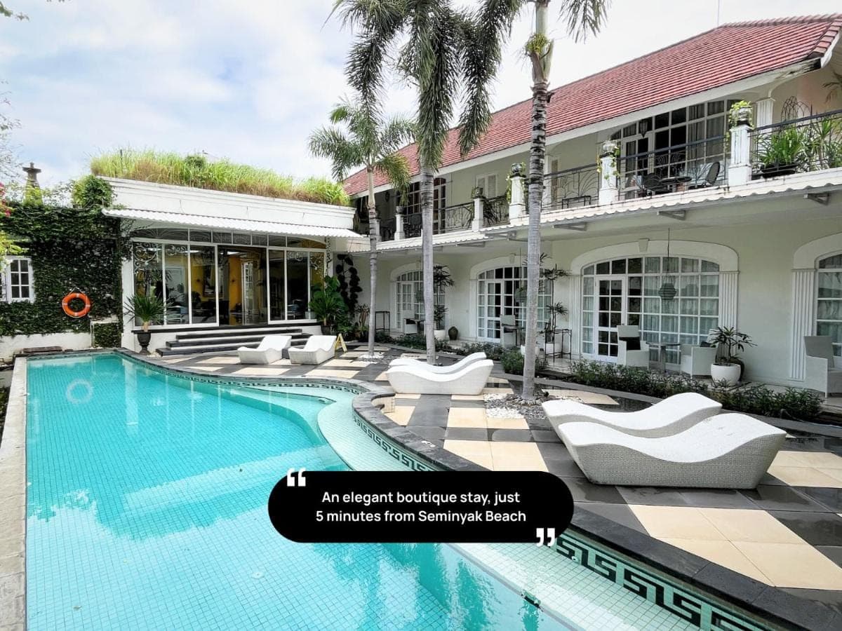 a resort with a swimming pool in front of a building at Casa Artista By Kresna Hospitality in Seminyak