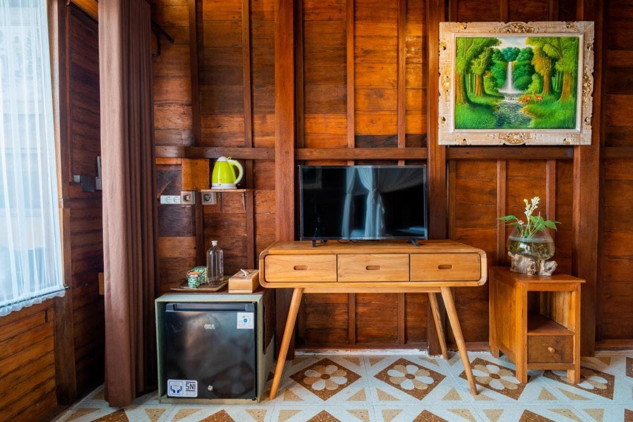 a room with a television and a desk with a tv at Mai Mucuk Lumbung in Canggu